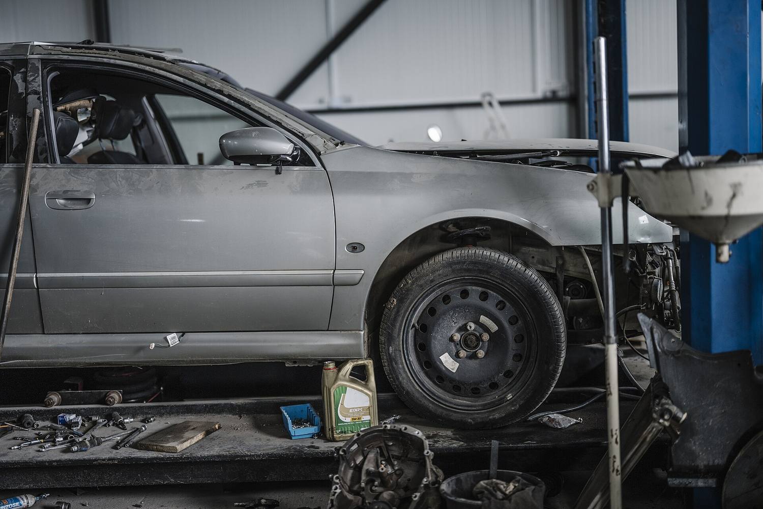 A car raised on a lift inside a repair shop