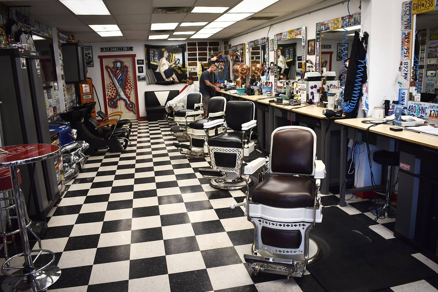 A barbershop with a black and white checkered floor and a row of chairs