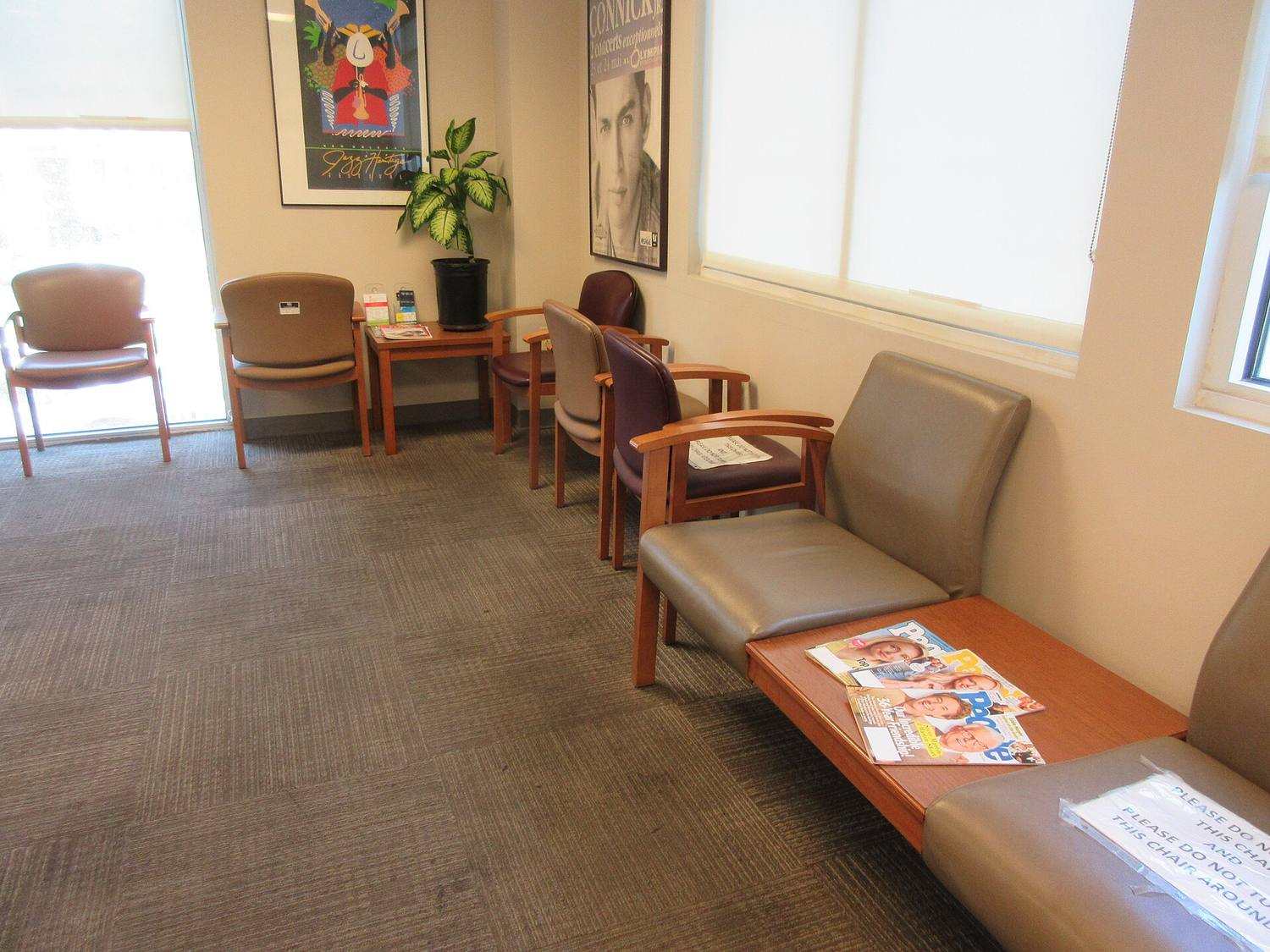 A calm waiting room with wood chairs and a window