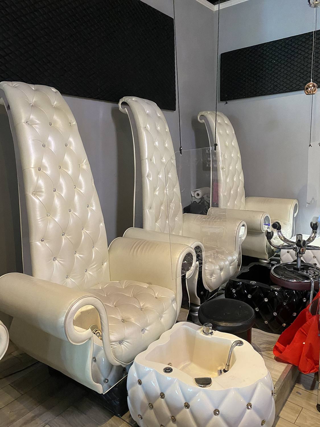White tufted pedicure chairs with foot basins