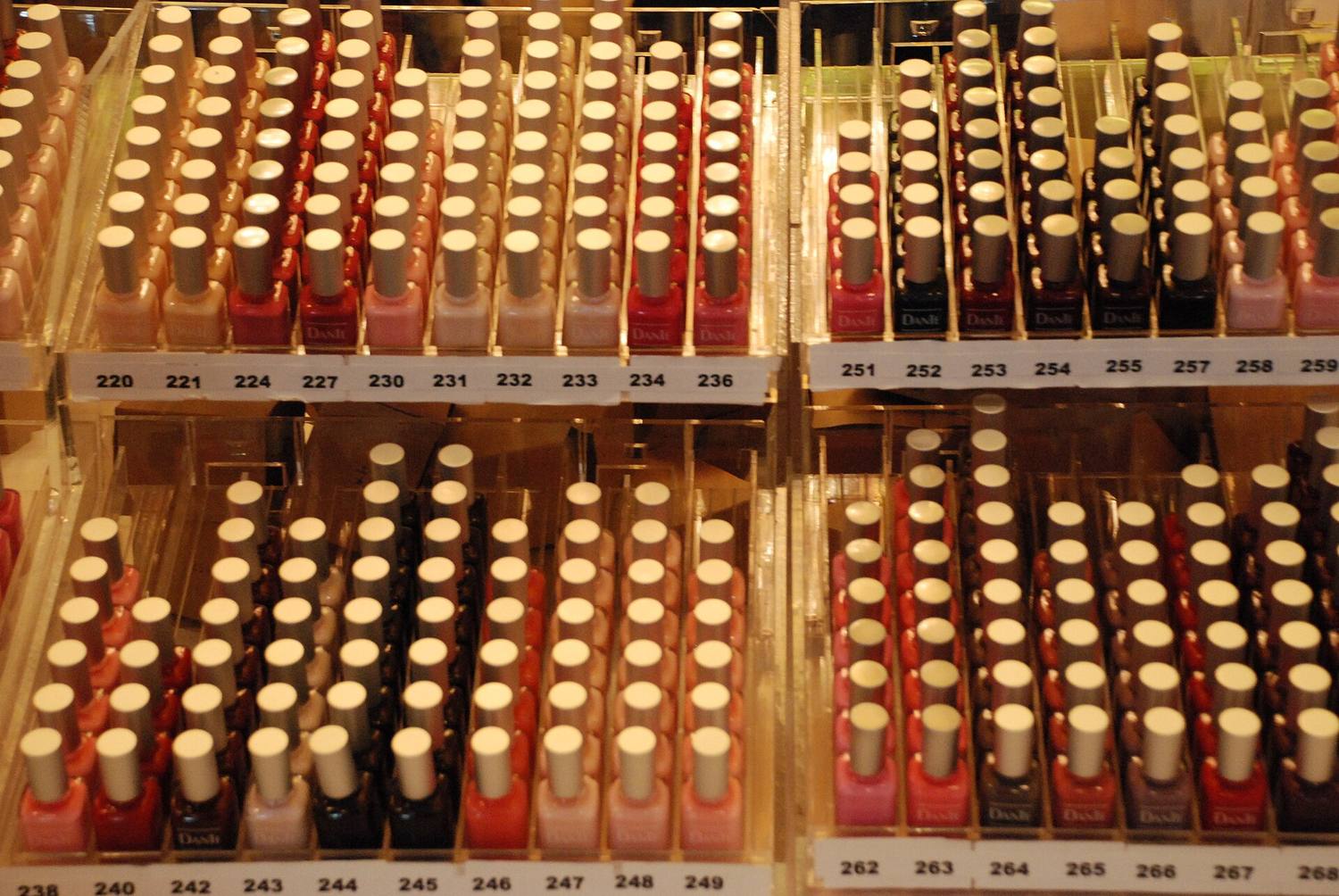 Rows of nail polish bottles in every color on a wall display
