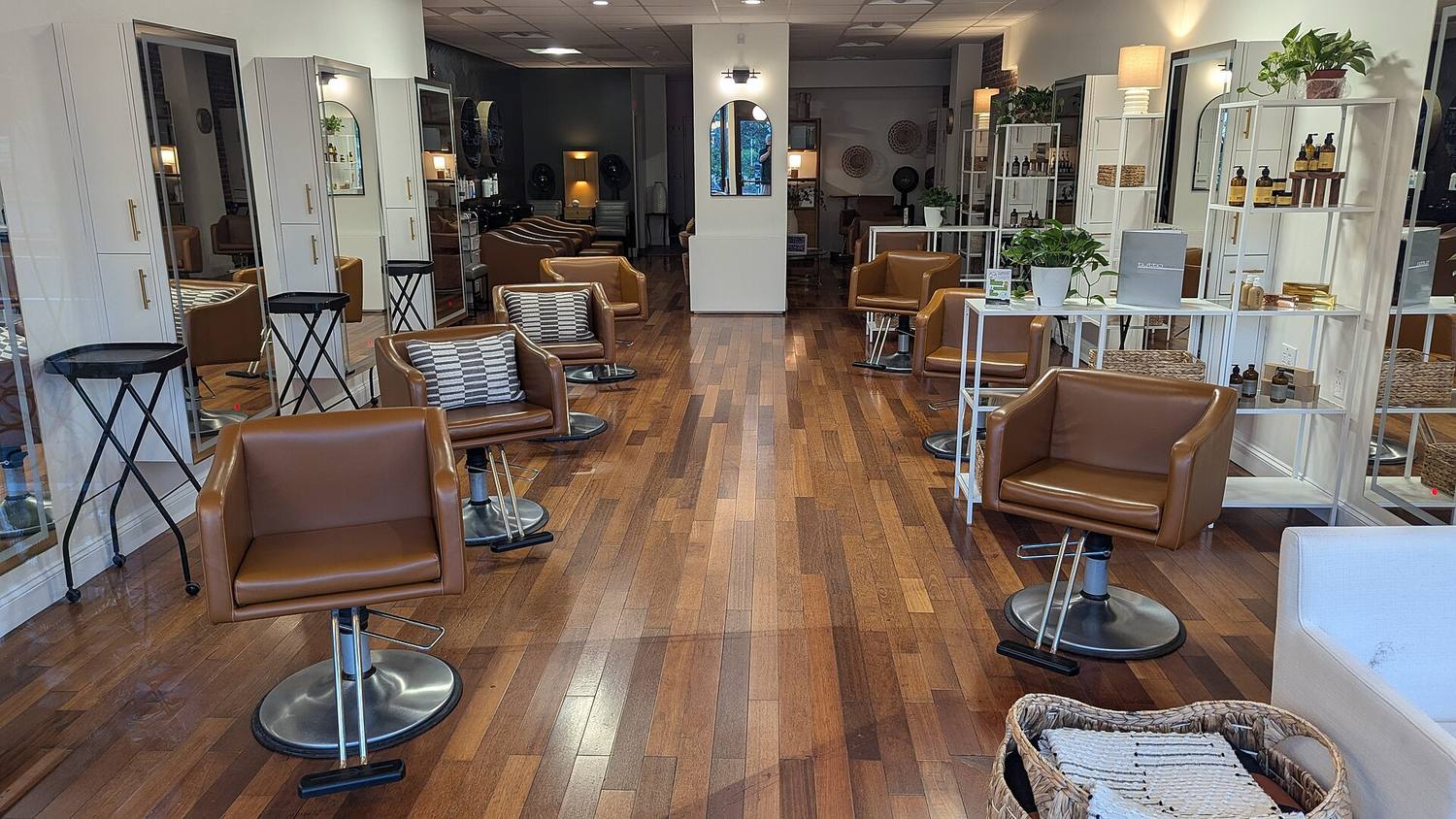 A bright salon with leather chairs, wood floors and plants