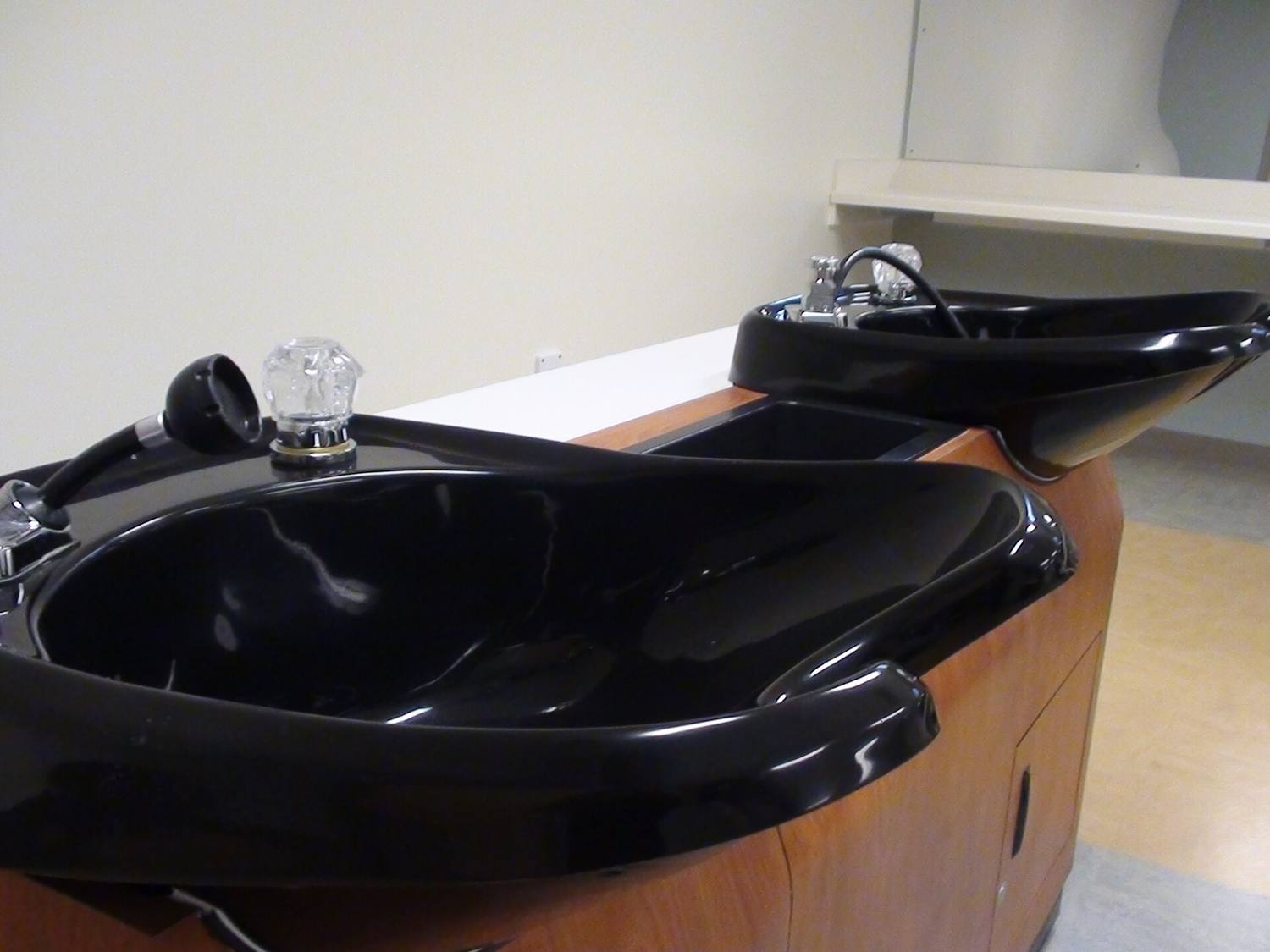 A black shampoo bowl at a salon wash station