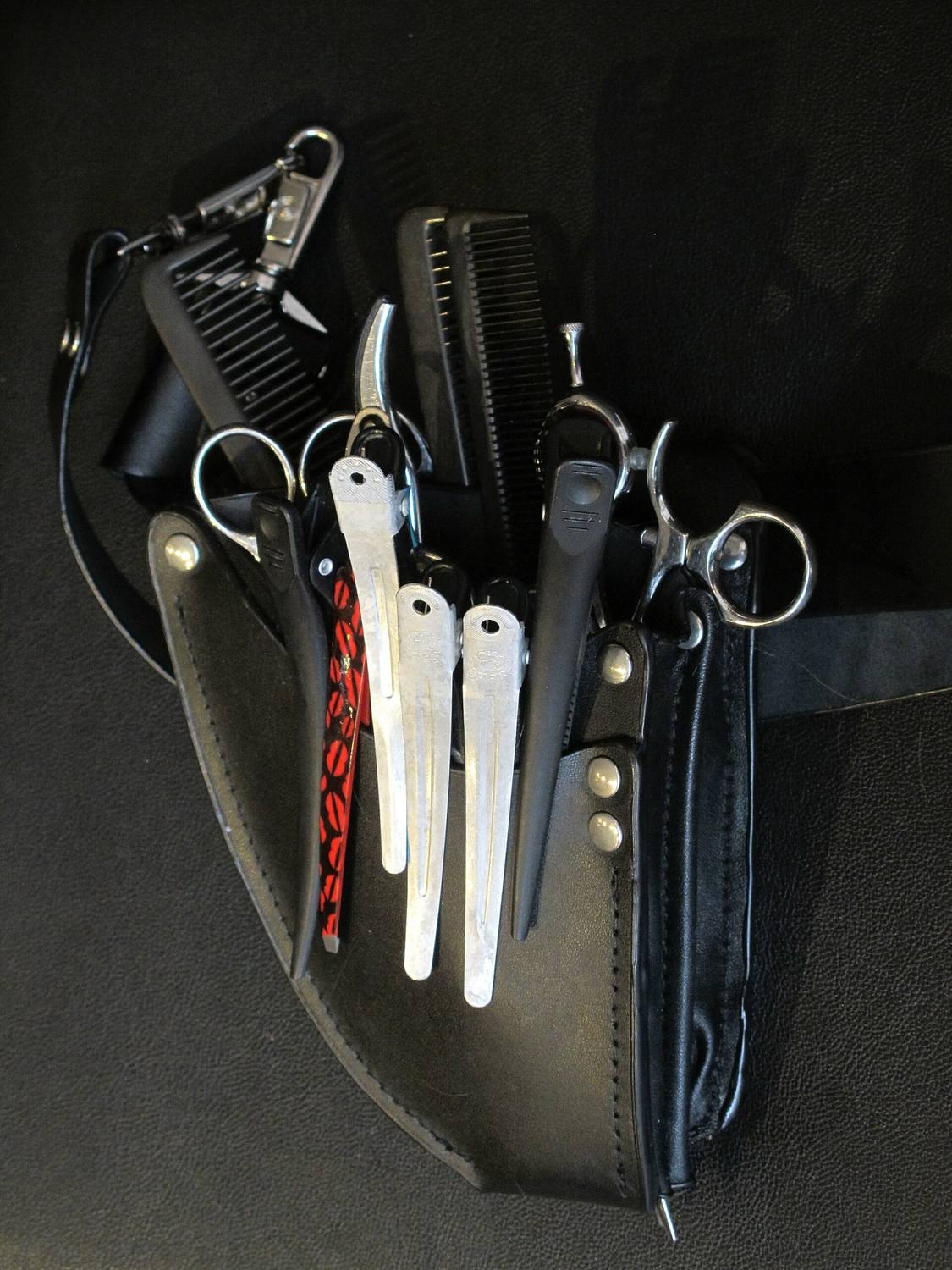 A stylist's holster with scissors, combs and clips